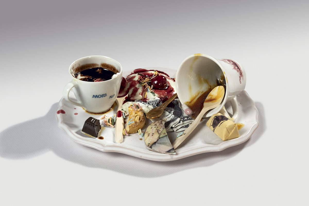 Bertozzi & Casoni, Pausa con dollaro, ceramica policroma. Un oggetto del quotidiano reso scultura, che unisce ironia e iperrealismo per riflettere sulla relazione tra consumo e valore.Collezione privata. Foto: © Nazario Spadoni